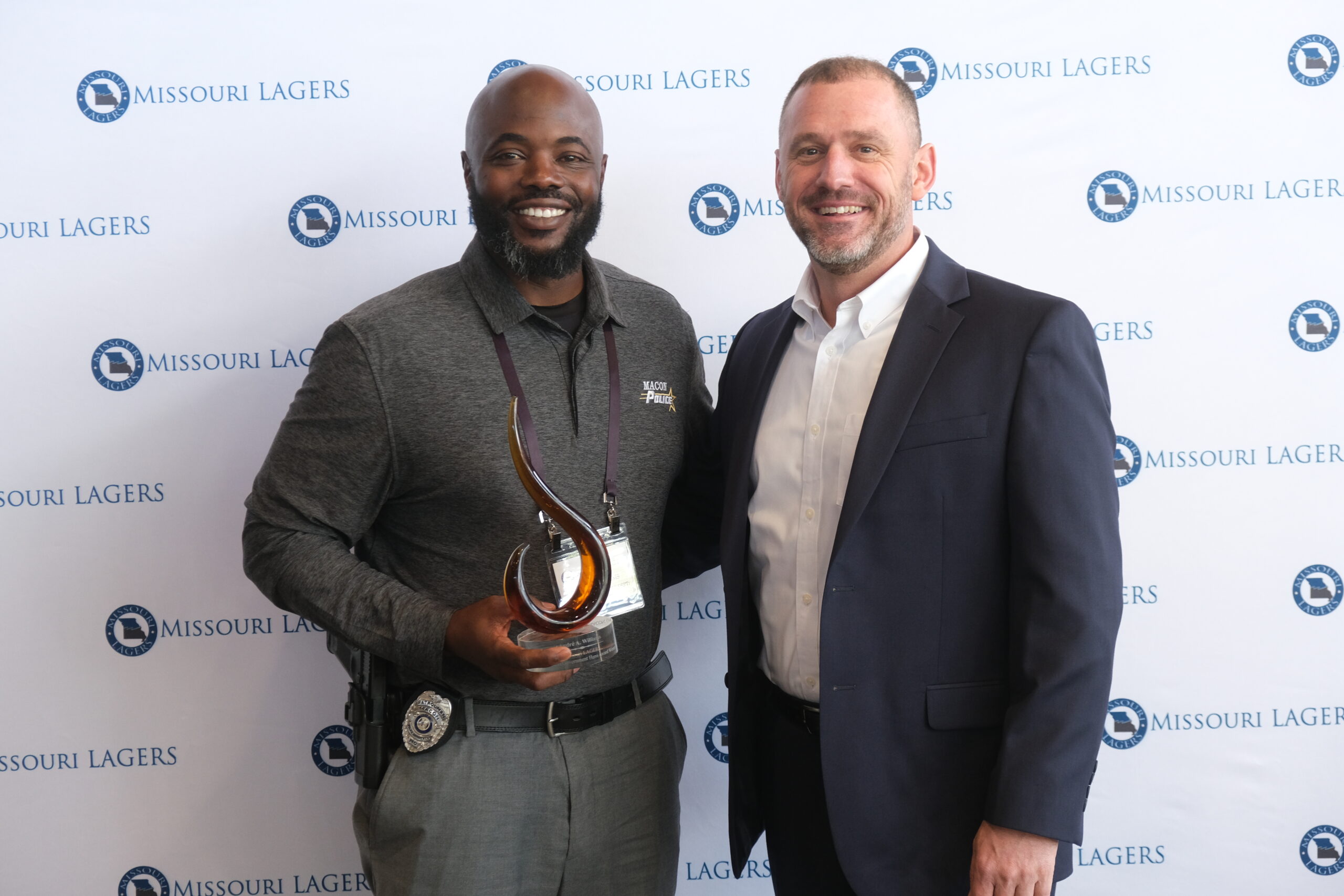 Andre Williams holding award and standing next to LAGERS' executive director.