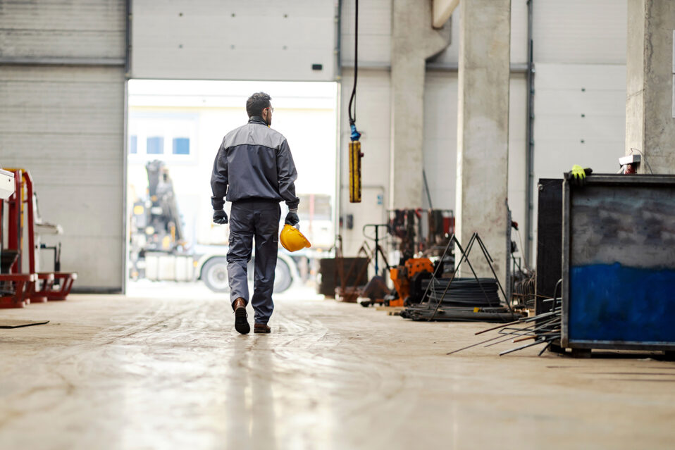 A worker walks out of a garage.