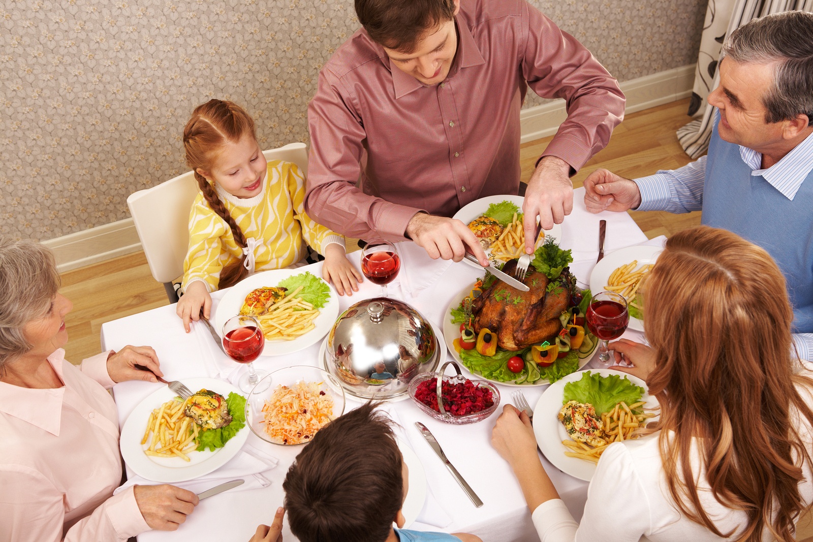 Image of big family sitting at festive table and eating salad and roasted turkey